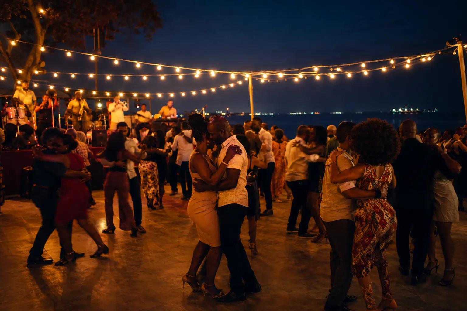 Couples dancing kizomba at an open-air venue on the Ilha in Luanda at night