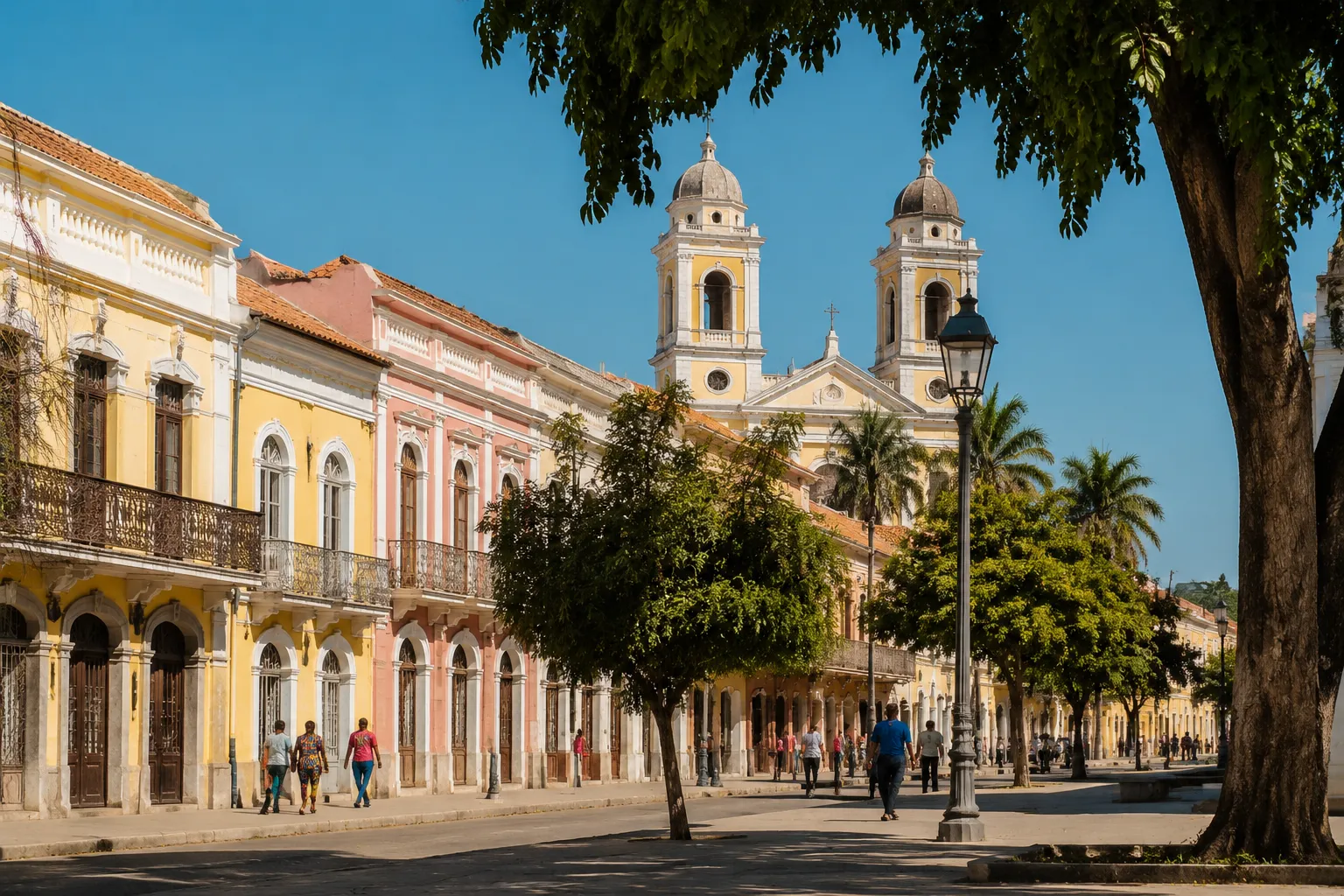 A sunlit avenue of pastel colonial buildings and the São Filipe Cathedral towers in central Benguela