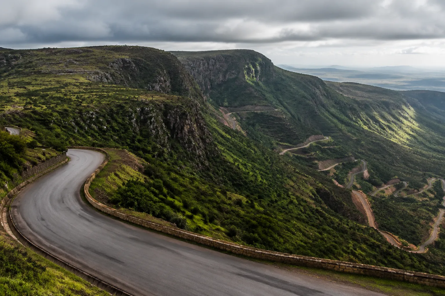 A tarred road curving through the green hills near Lubango towards the Serra da Leba pass